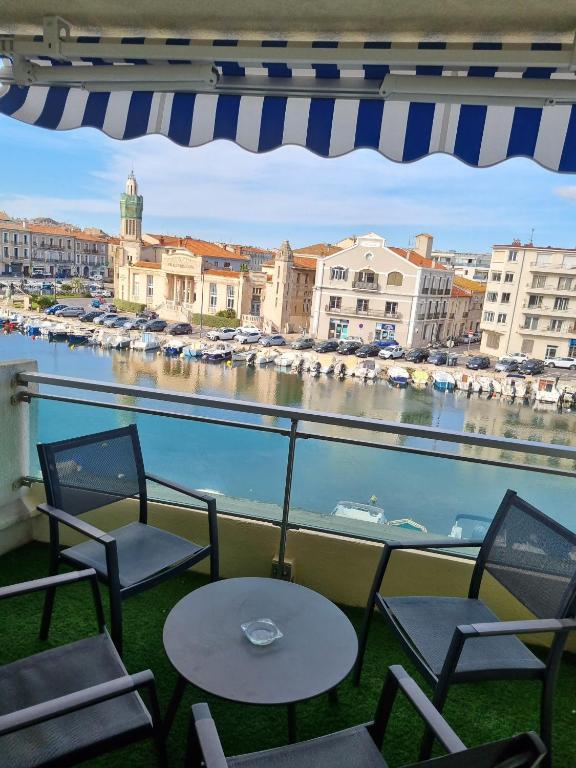 d'un balcon avec des chaises et des tables offrant une vue sur le port. dans l'établissement Sete T3 sur les quais en centre ville parking, à Sète