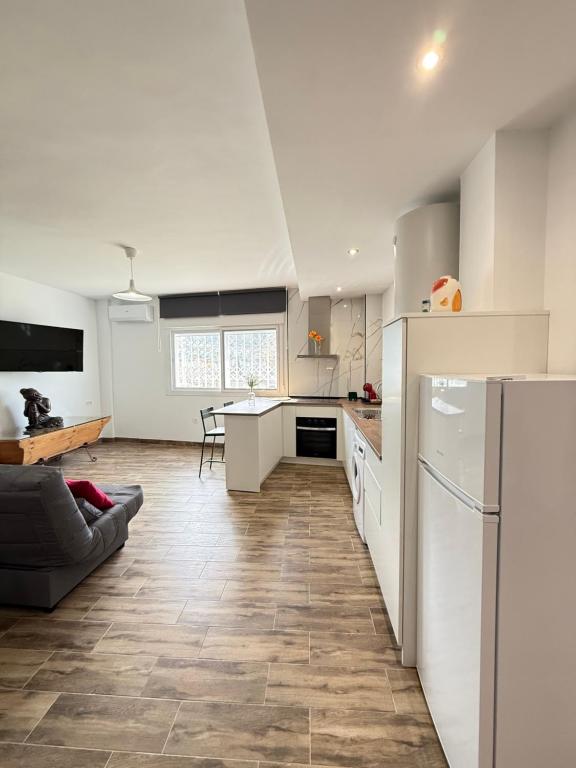 a kitchen with white appliances and a table in a room at Casa De la Vega in Cenes de la Vega