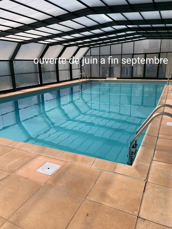 ein großes Schwimmbecken mit den Worten ambulant, das einen festen Übergang herbeiführt in der Unterkunft Ossau T2 5 personnes piscine climatisation 1 chambre draps serviettes inclus parking moustiquaires lave vaisselle lave linge tout confort in Bielle