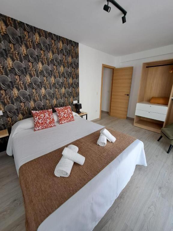 a bedroom with a large bed with towels on it at Chloe Apartments TRG in Benidorm