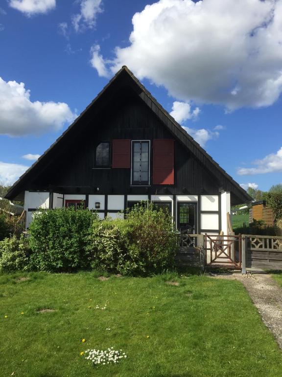 a black and white house with a green yard at Ferienhaus Hygge in Kappeln