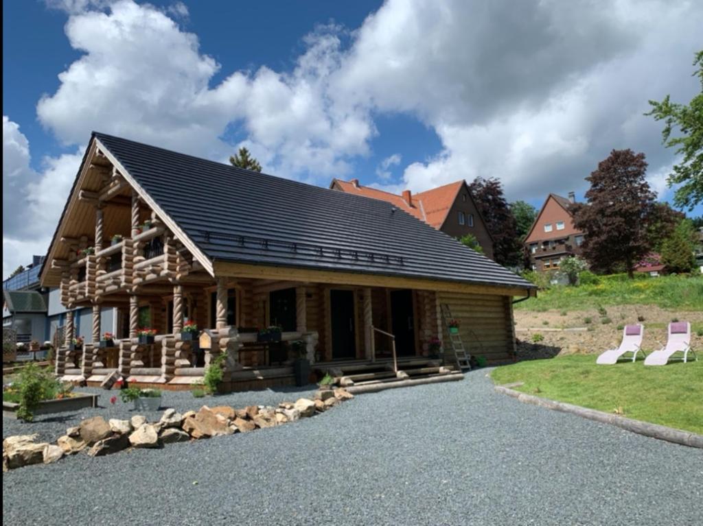 a log home with a gambrel roof at Hahnenkleer Hütte Harzliebe in Goslar