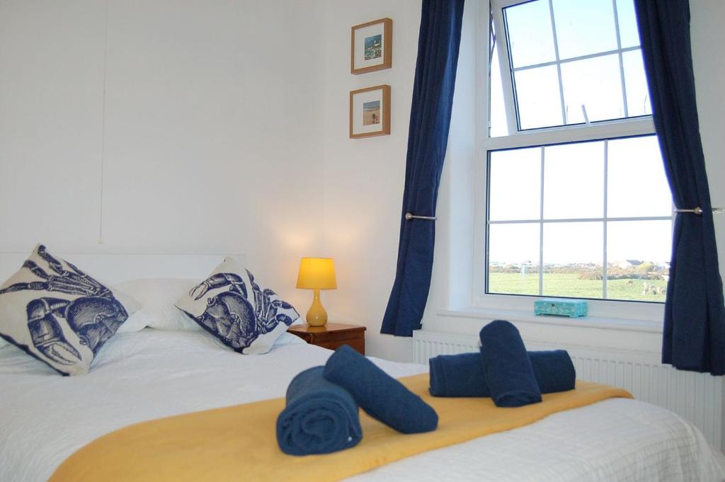 a bedroom with a bed with blue towels on it at Angorfa family holiday home with games room in Tywyn