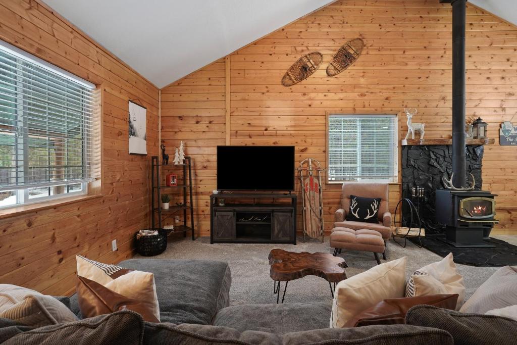 a living room with a couch and a television at Basecamp in La Pine