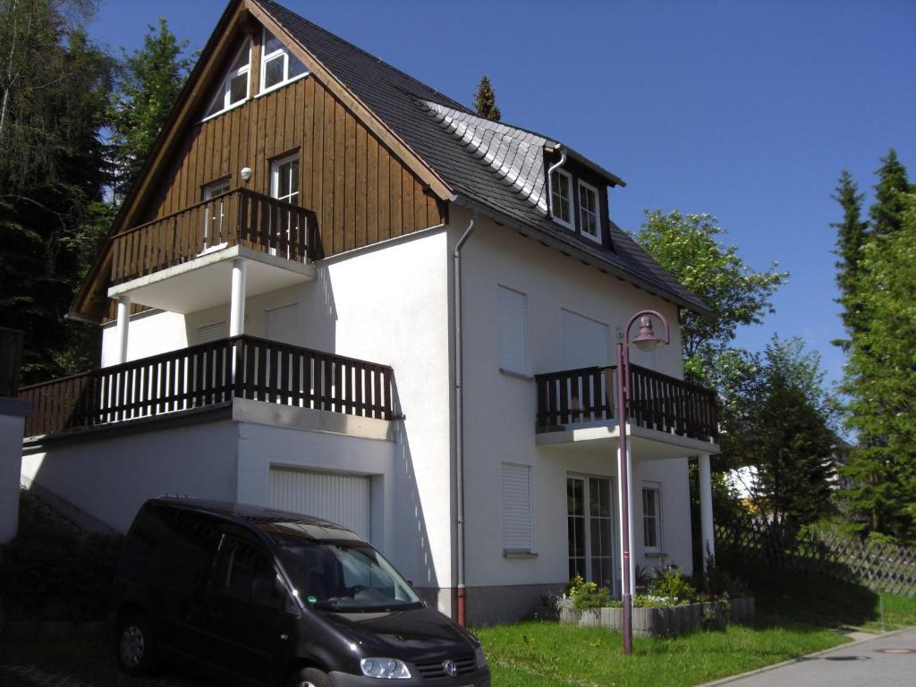 a car parked in front of a white house at Ferienwohnung Böcker in Oberwiesenthal