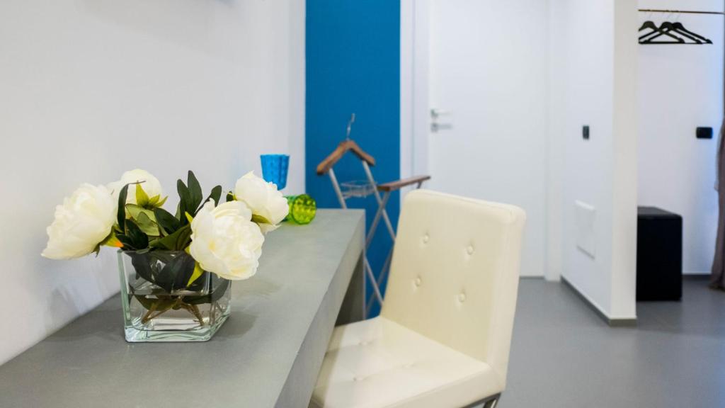 a vase filled with white flowers sitting on a table at New Dimora Valmar in Polignano a Mare