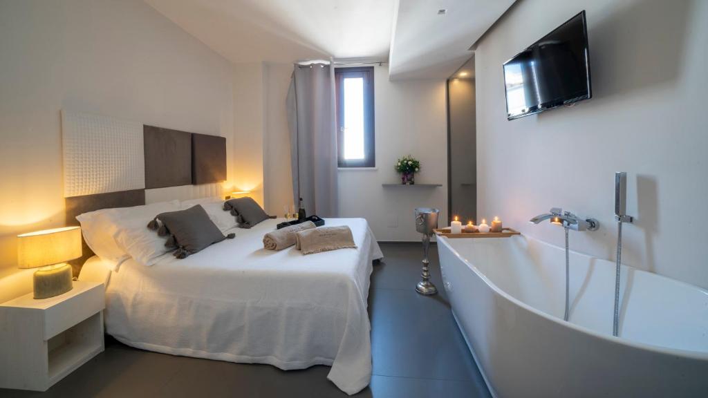 a bedroom with a large bed and a bath tub at New Dimora Valmar in Polignano a Mare
