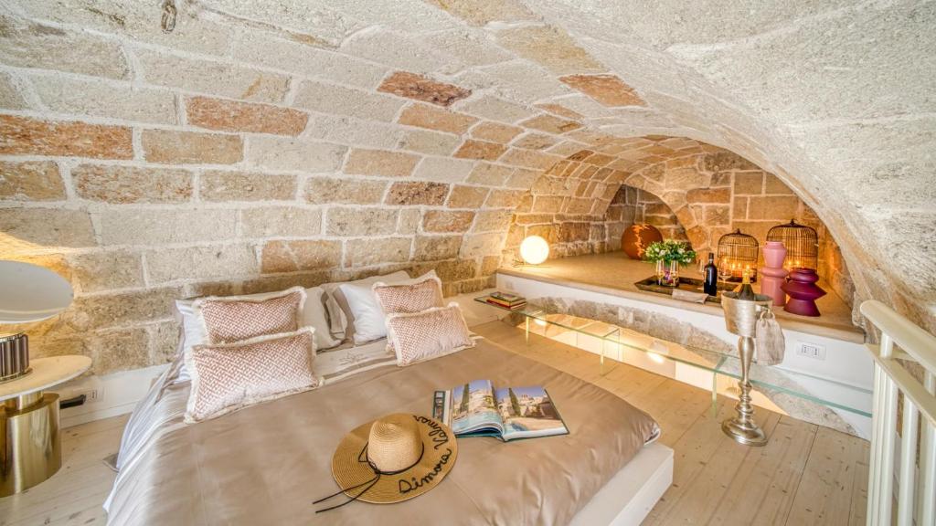 a room with a bed and a stone wall at New Dimora Valmar in Polignano a Mare