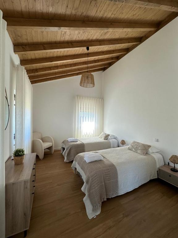 ein Schlafzimmer mit zwei Betten und einer Holzdecke in der Unterkunft Casas da Pereira in Barcos