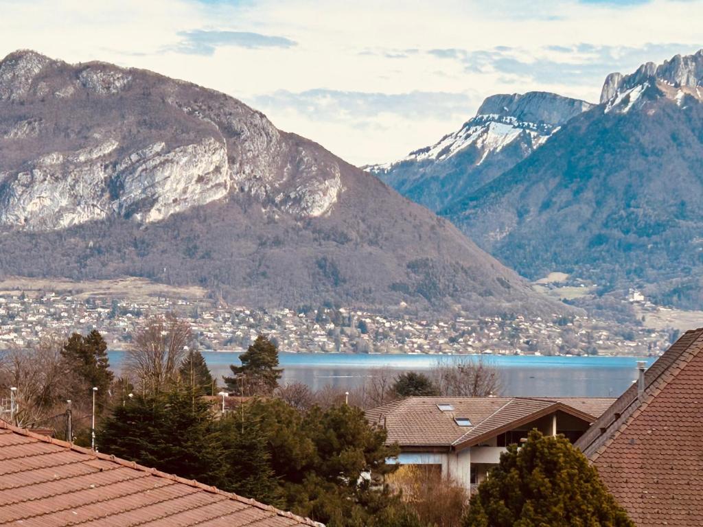 - une vue sur le lac et les montagnes avec des maisons dans l'établissement Maison de Famille Vintage Cosy, à Sévrier