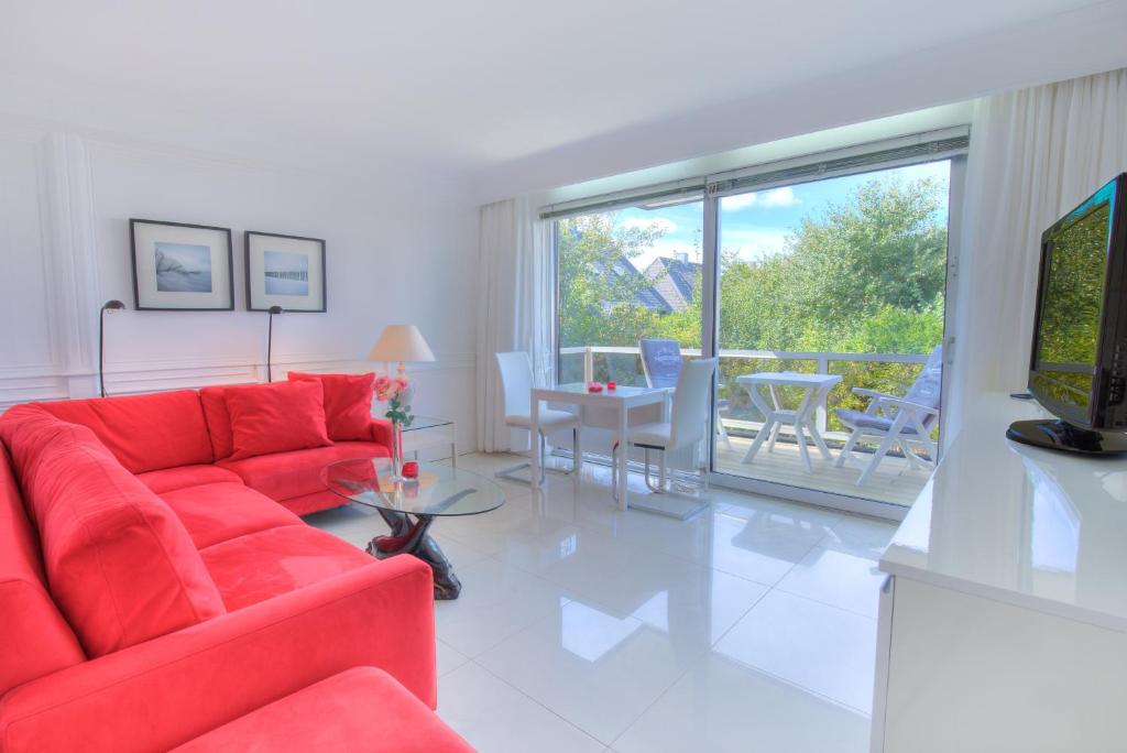 a living room with a red couch and a table at Windeby 4E in Wenningstedt