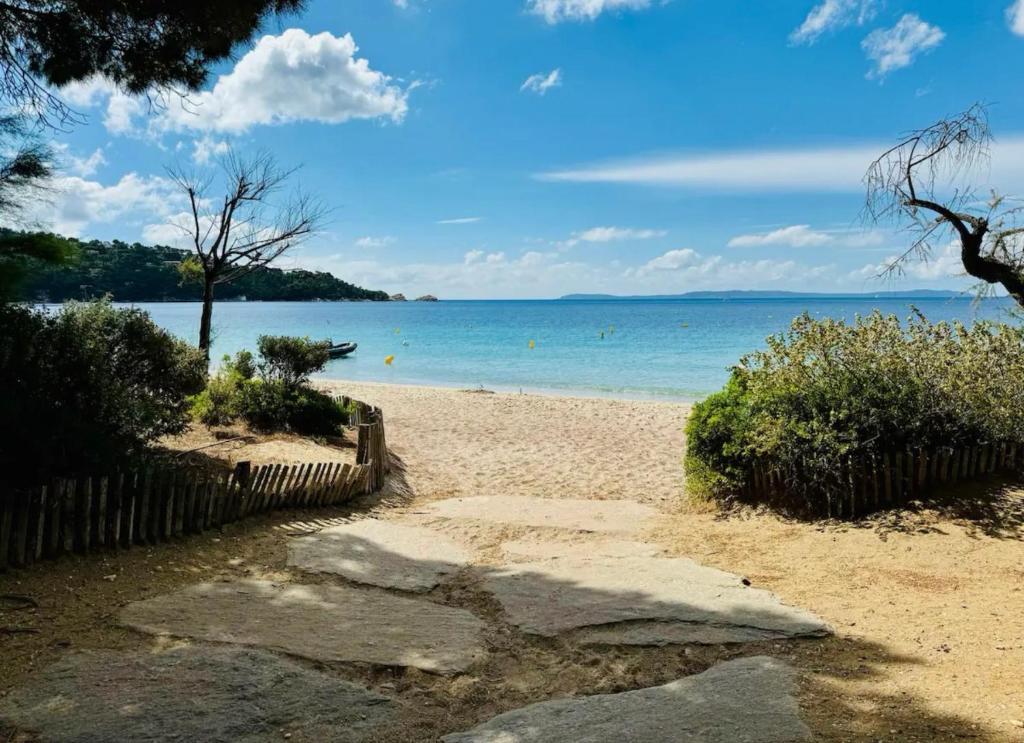 une plage avec l'océan en arrière-plan dans l'établissement Superbe appartement climatisé avec wifi classé 3 étoiles à 50 m de la plage Le Lavandou, au Lavandou