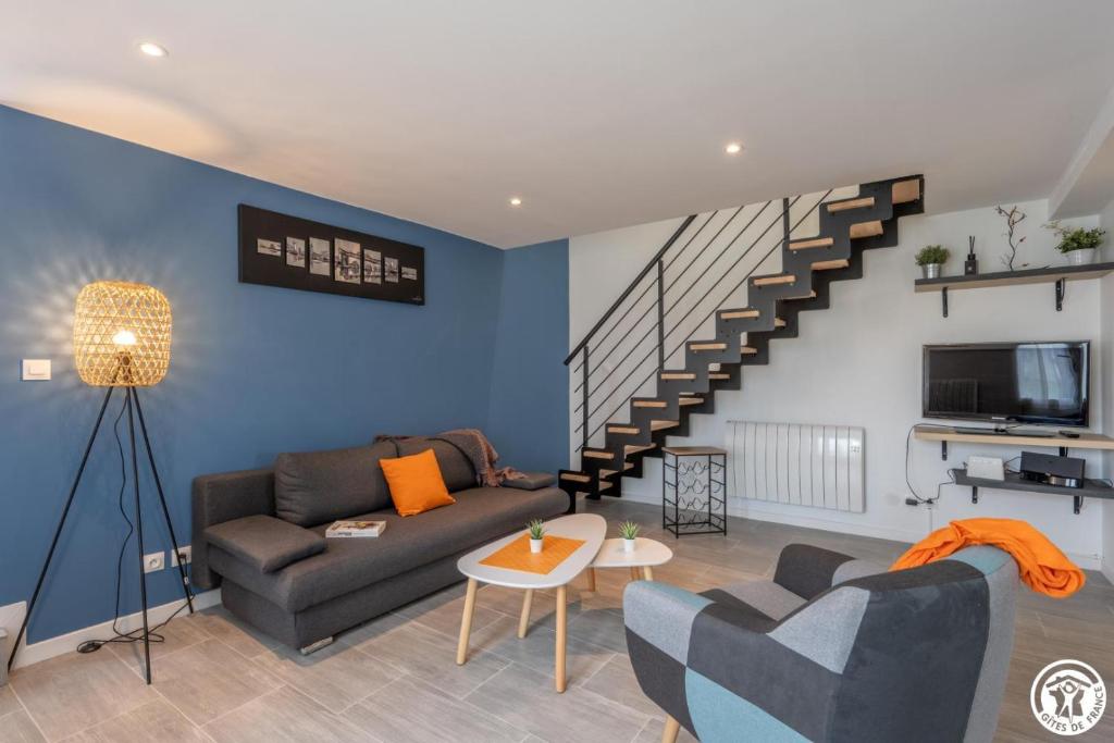 a living room with a couch and a staircase at Nou kontan vwe-zot in Abbecourt