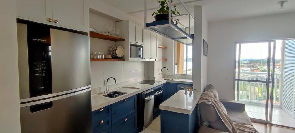 a kitchen with blue cabinets and a sink at Comforto a Beira-Mar com Vista Deslumbrante in Barra Velha