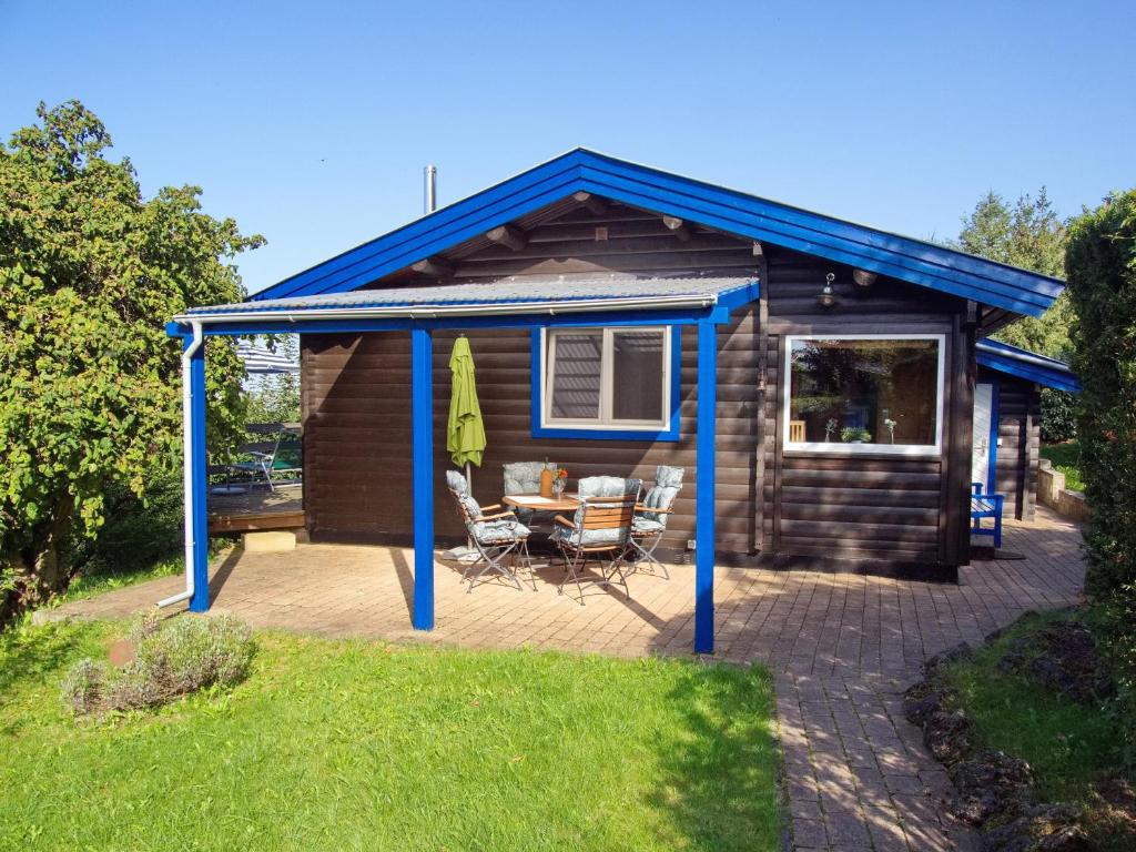 a cabin with a blue roof and a patio at Diemelsee Sudeck - Ein Ferienhäuschen zum WOHLFÜHLEN in Diemelsee