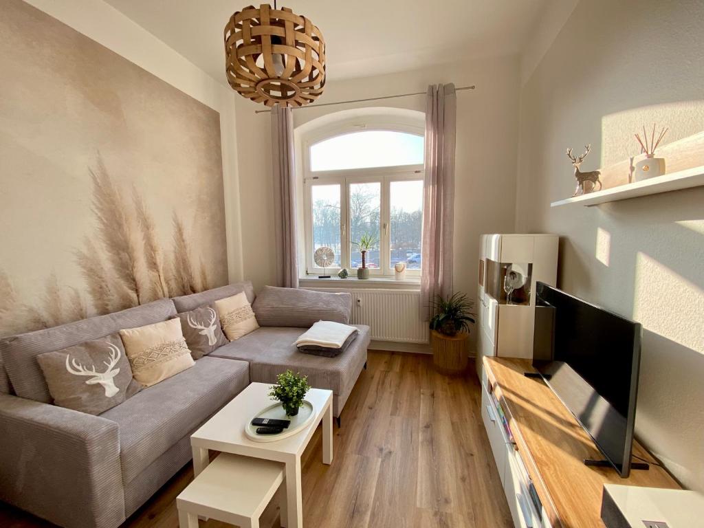 a living room with a couch and a tv at Ferienwohnung Parkblick in Arnstadt