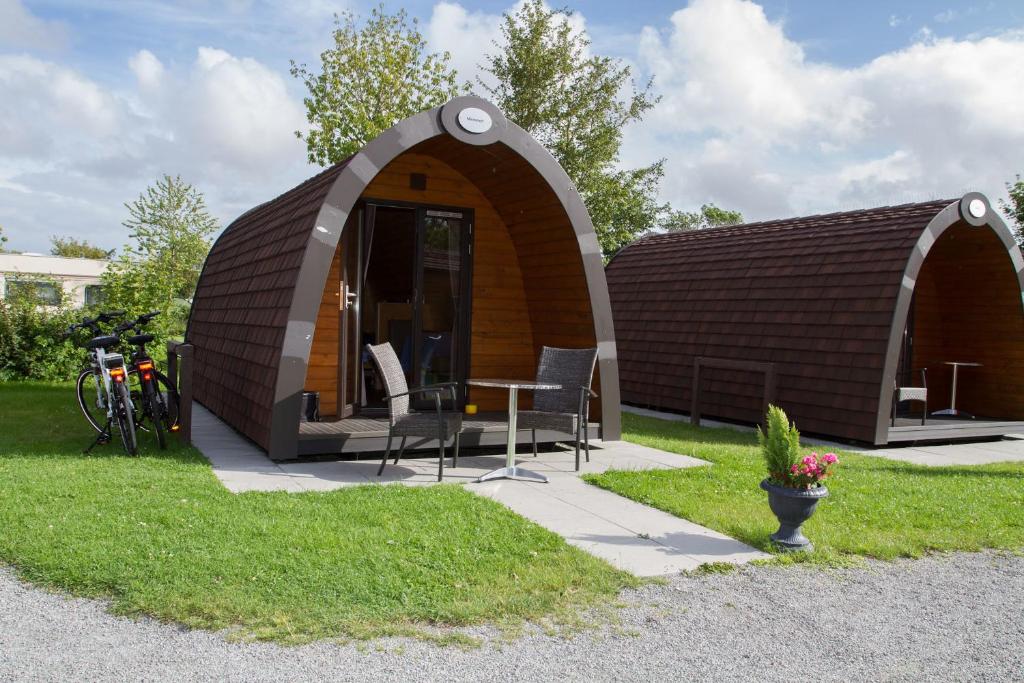 ein kleines Gebäude mit einem Tisch und Stühlen im Hof in der Unterkunft Kleine Nordseewelle ohne Hund in Norden