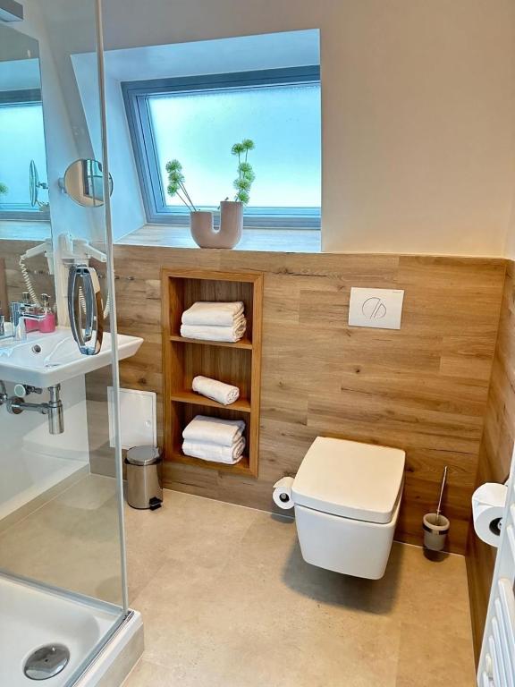 a bathroom with a toilet and a sink and a window at Appartment Düne 7 2OG Grundbelegung 2 Pers in Elsterheide
