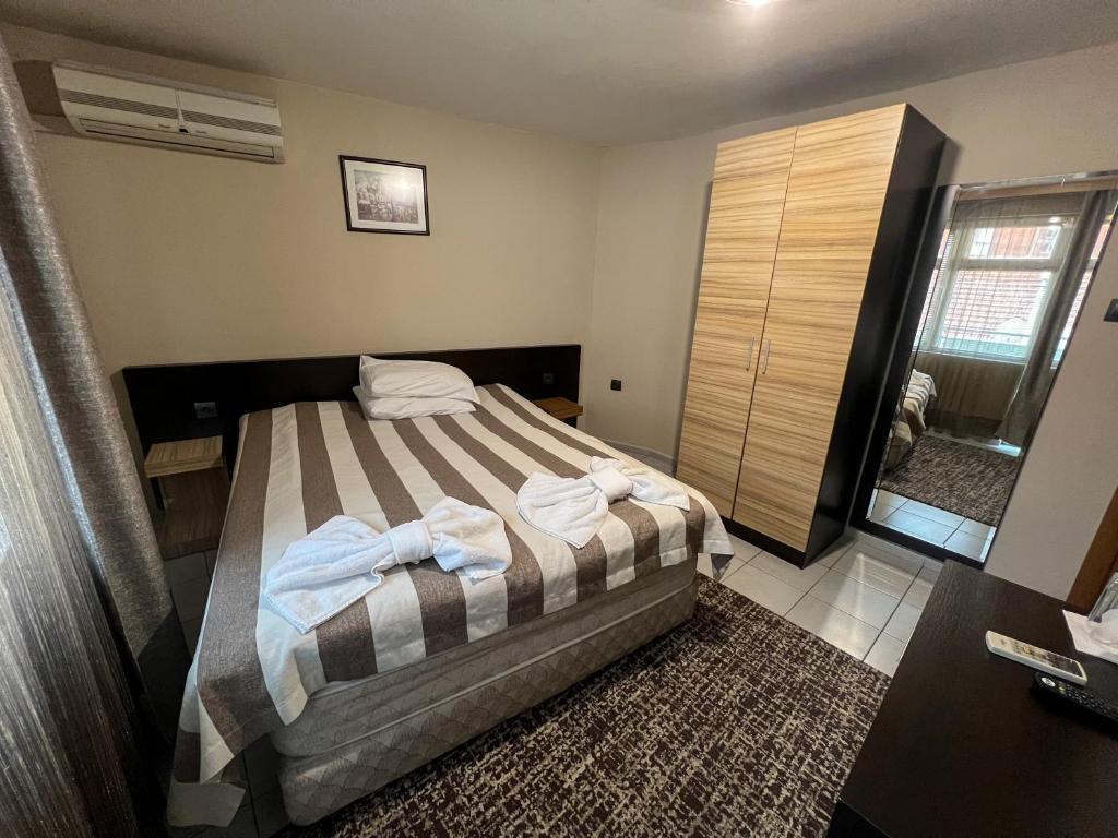 Un dormitorio con una cama con toallas. en ALPHA family HOTEL, en Blagoevgrad