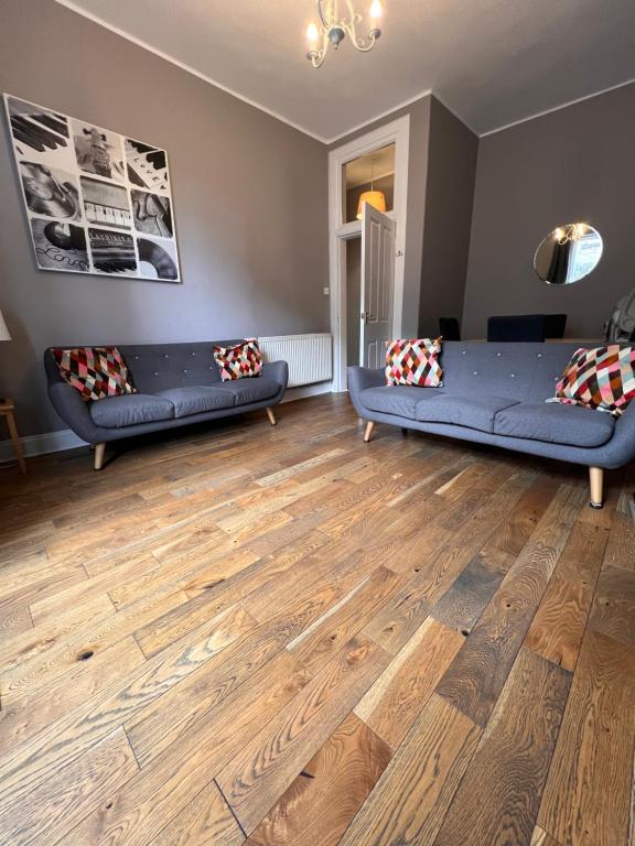 - un salon avec des canapés bleus et du parquet dans l'établissement John Knox's Apartment on Edinburgh's Royal Mile, à Édimbourg