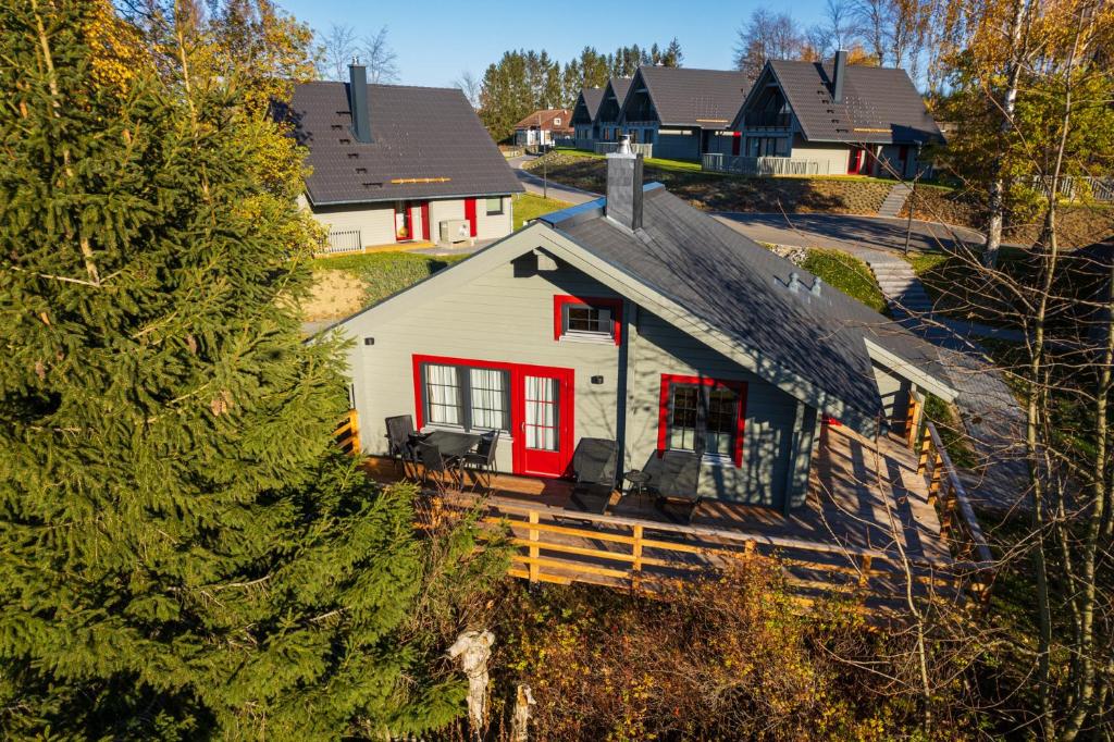 a white house with red trim in a residential neighborhood at Alm-Lodge 2 in Clausthal-Zellerfeld