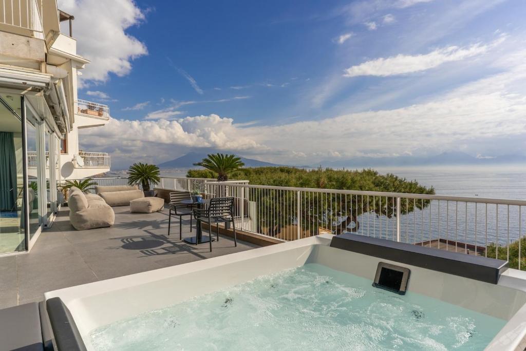 a hot tub on a balcony with a view of the ocean at Petrarca Boutique Apartment - Sofia Apartments in Naples