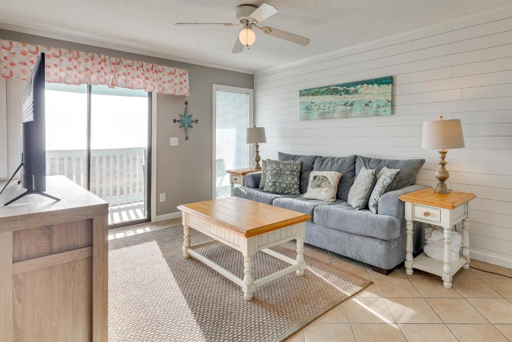 a living room with a couch and a tv at Balcony with Ocean Views Carolina Beach Condo! in Carolina Beach