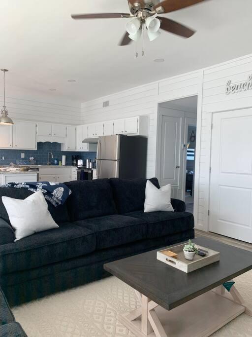 a living room with a black couch and a table at Coastal Condos on the Marsh 6B in Dauphin Island