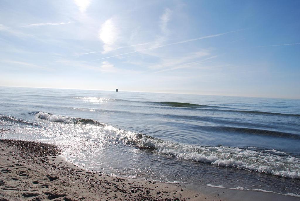 a beach with the ocean and a person in the distance at "NordWest" Ferienwohnung in Prerow