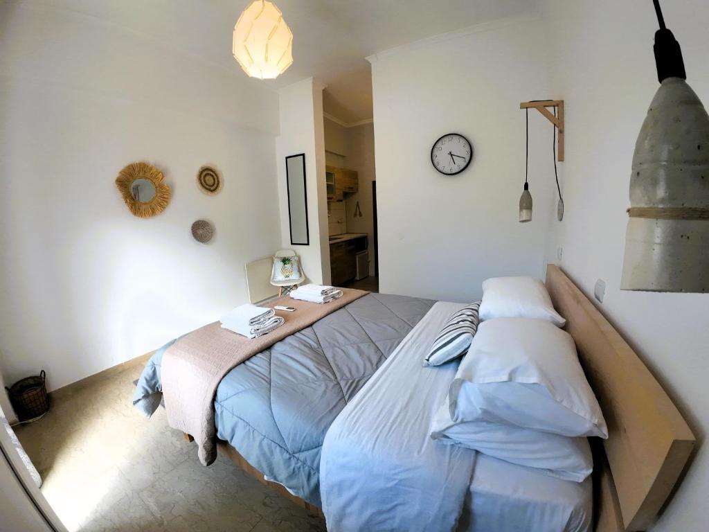 a bedroom with a bed and a clock on the wall at Studios Paleokastritsa - Sun's Gift in Paleokastritsa