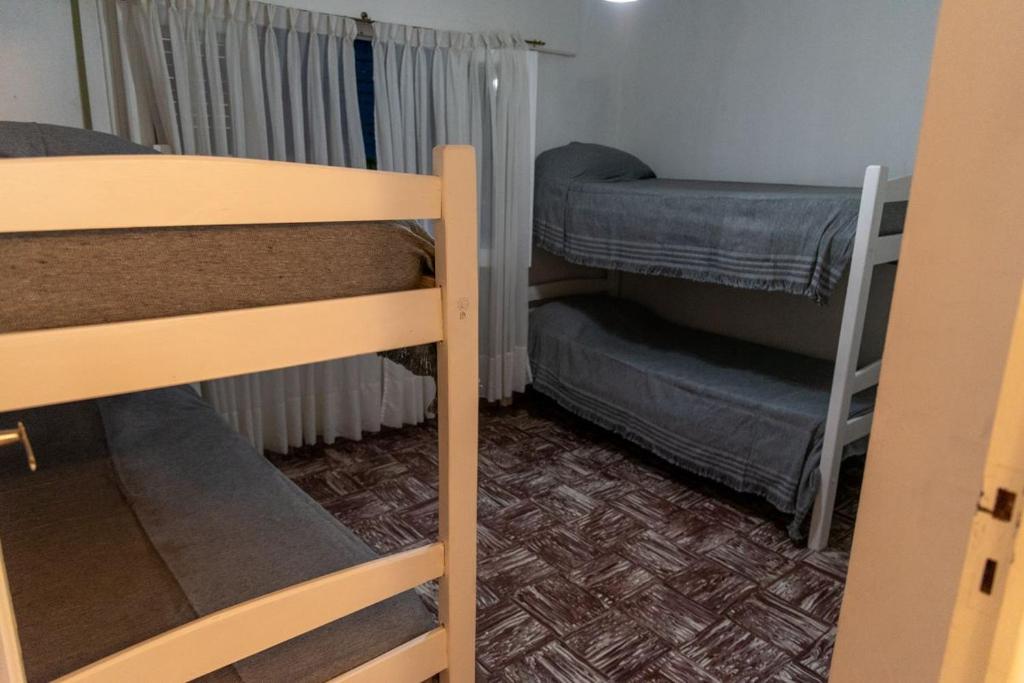 een kleine kamer met 2 stapelbedden en een raam bij Gen Viajero Hostel in Merlo