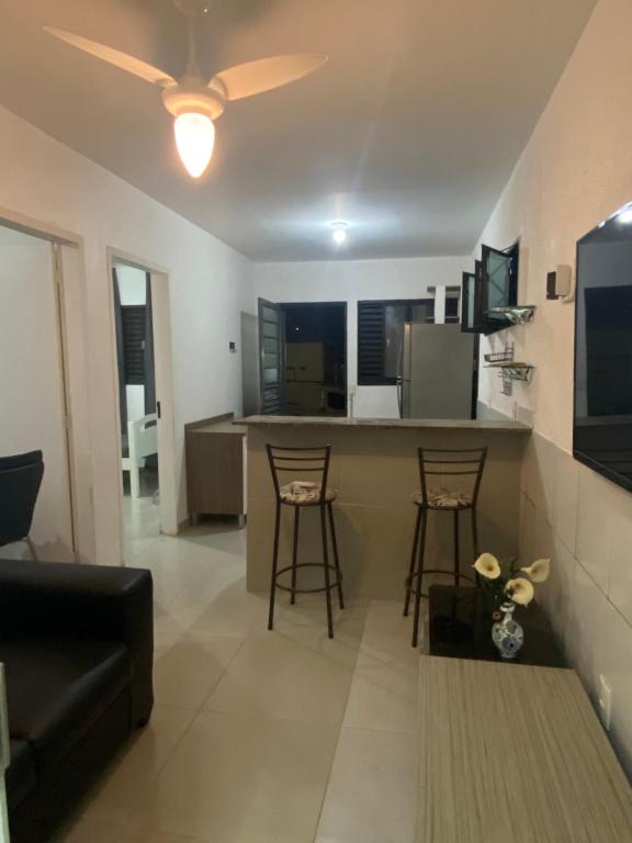 a living room and kitchen with a couch and a table at Apartamento térreo próximo ao Iguatemi in Torto