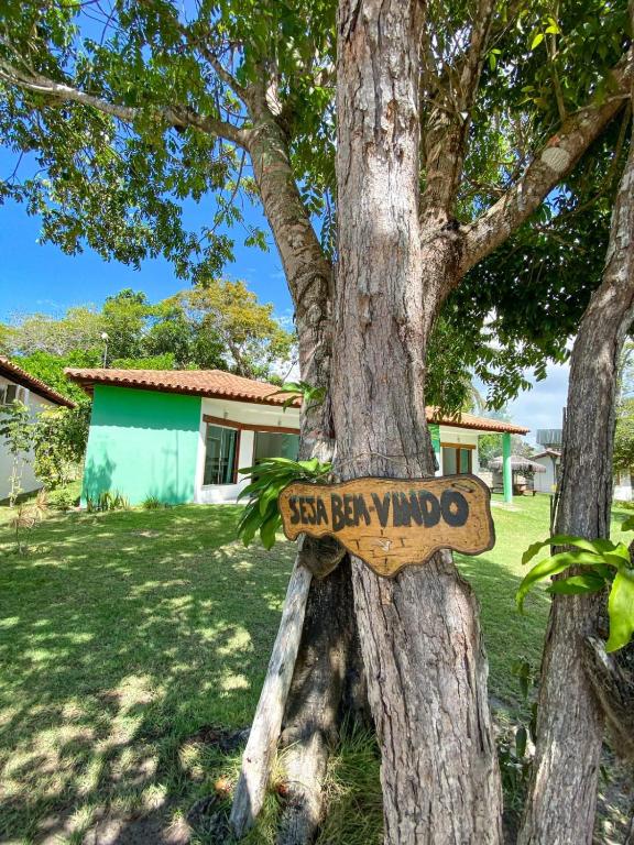 a sign on a tree in a yard at Corumbau Recanto dos Pássaros in Corumbau