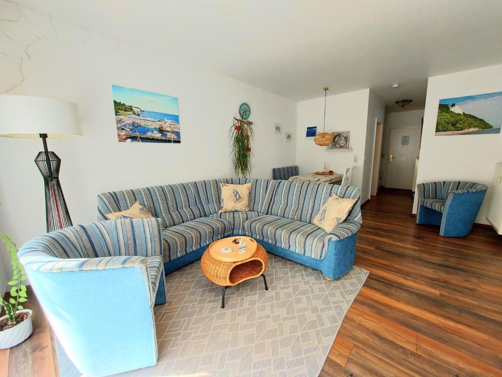 a living room with a blue couch and a table at Komfortferienwohnung Leuchtturm in Sassnitz