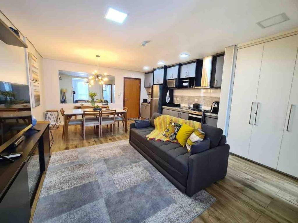 a living room with a couch and a dining room at Loft aconchegante próximo ao Capivari in Campos do Jordão