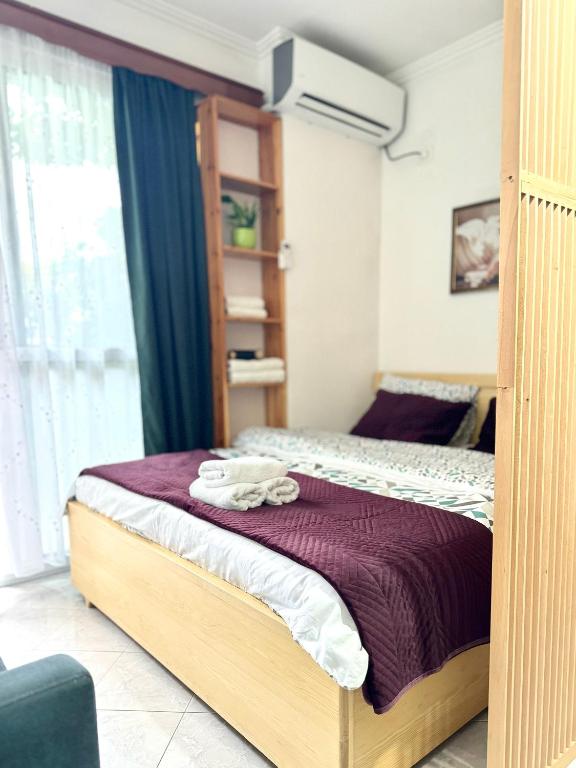 a bedroom with a bed with a purple blanket at Studio Astir in Tirana