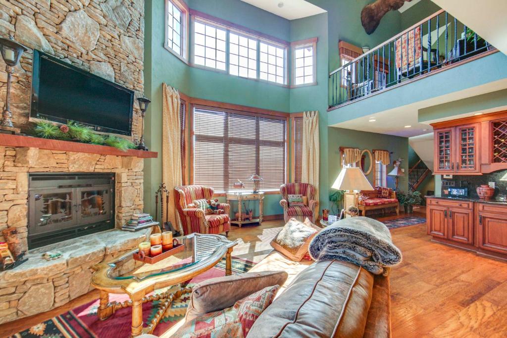un soggiorno con divano e camino di Seven Springs Resort Home Theater Room and Grill a Champion