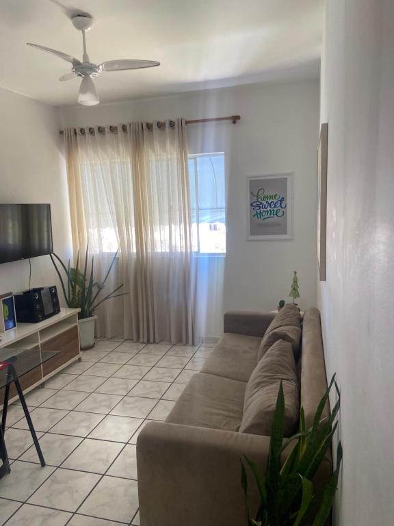 Una sala de estar con un sofá y un ventilador de techo. en Rio Vermelho, en Salvador