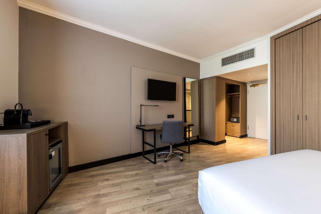 a hotel room with a bed and a desk at NH Luxembourg Airport in Luxembourg
