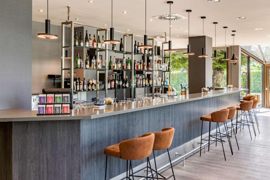 a bar in a restaurant with stools at NH Luxembourg Airport in Luxembourg