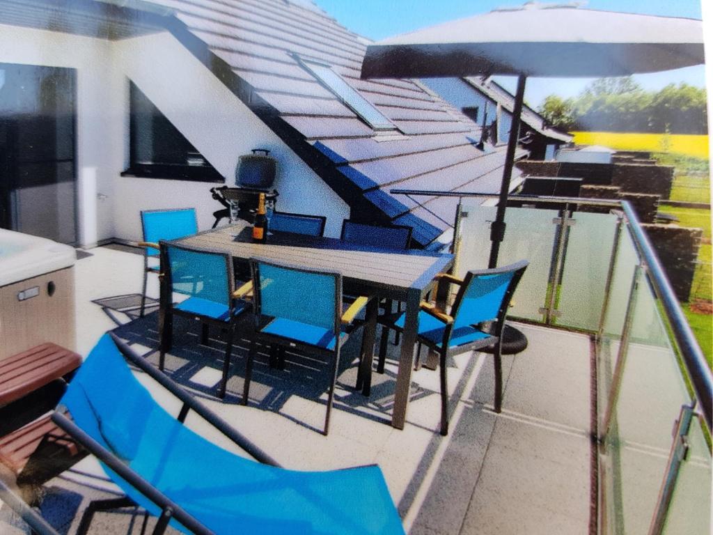 een terras met een tafel en stoelen en een parasol bij Villa Aquila Luxus-Maisonette Ferienträume Dachterrasse in Göhren-Lebbin
