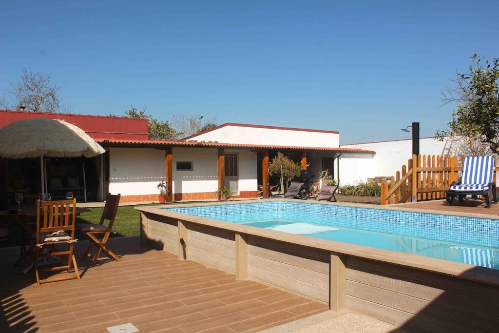 a swimming pool with chairs and a house at Castro's guesthouse in Viana do Castelo