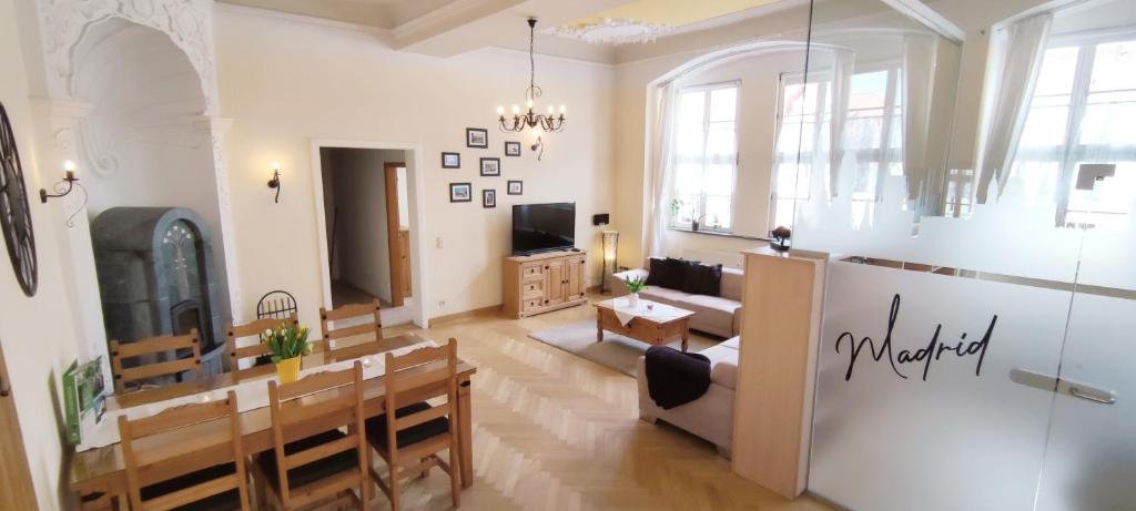 a large living room with a table and a couch at Apartment Madrid Garten & Pool als Extra möglich barrierefrei in Mühlhausen