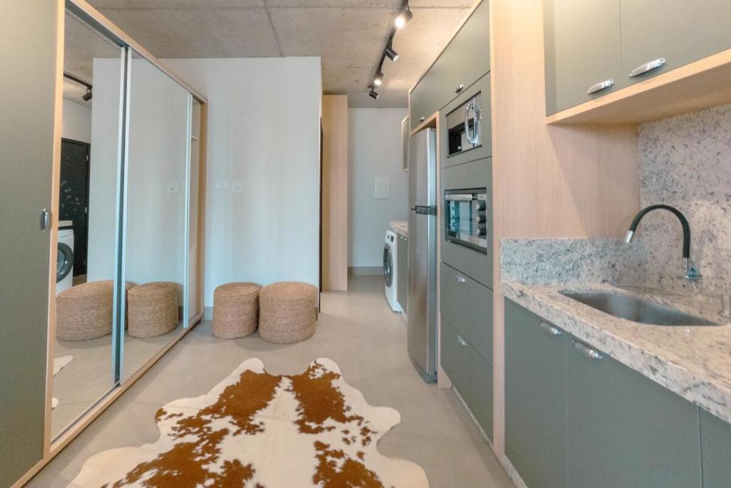 a large kitchen with a rug on the floor at Seu Refúgio Sofisticado no Centro de Maringá in Maringá