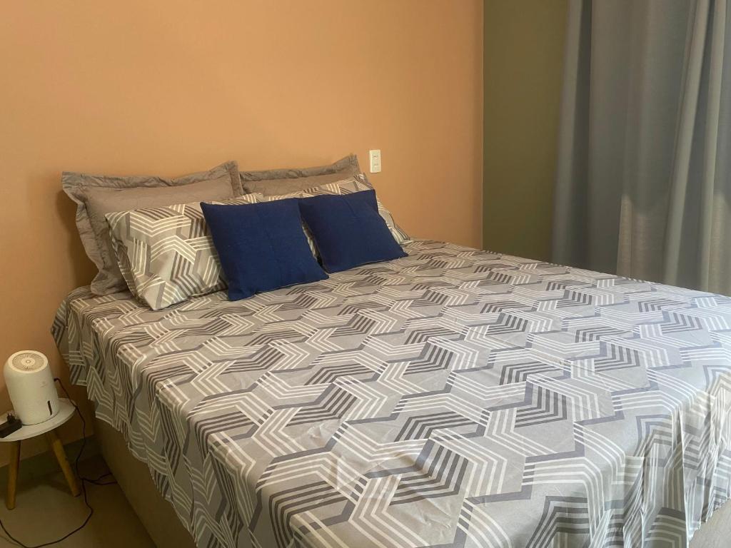 a bed with blue pillows in a bedroom at Suíte 1 Praia do Grant in Barra Velha