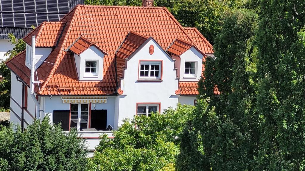 a white house with an orange roof at Apartment Kunsthaus Panorama 1 OG mit Balkon in Nordhausen