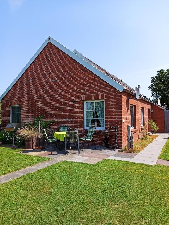 a brick house with a table and chairs in the yard at Up Höcht in Osteel