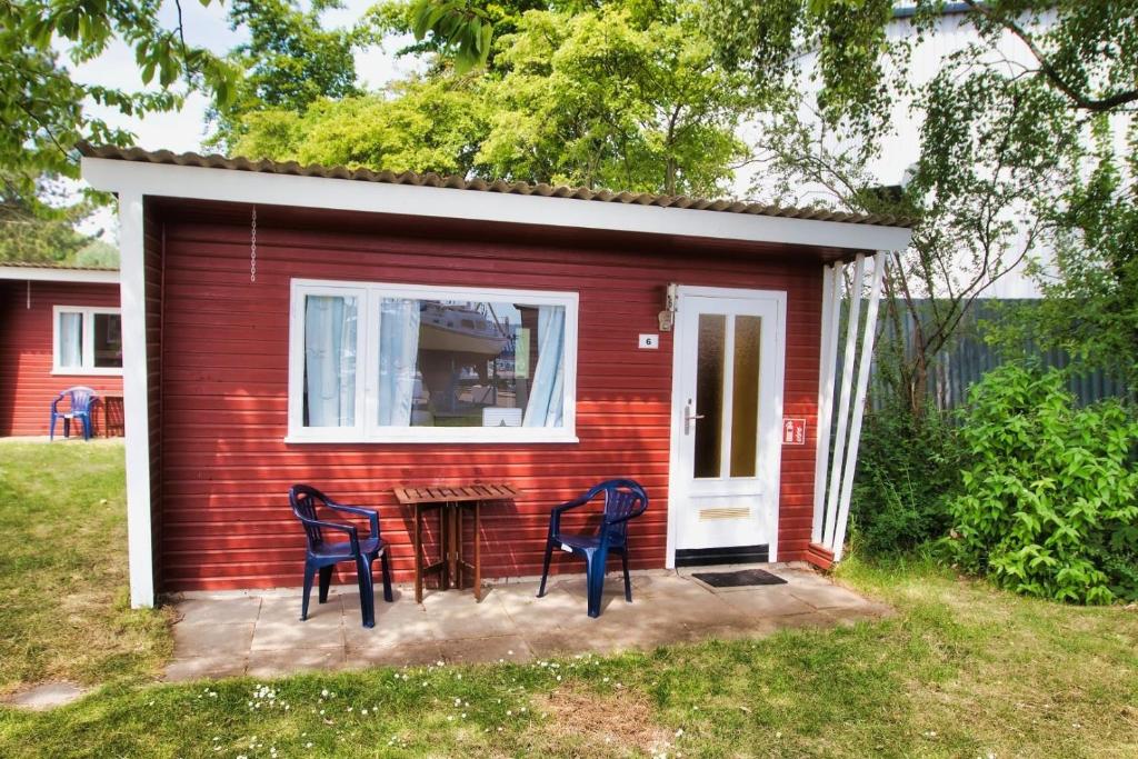una casa rossa con due sedie blu fuori di Finnenhaus 6 a Lubecca