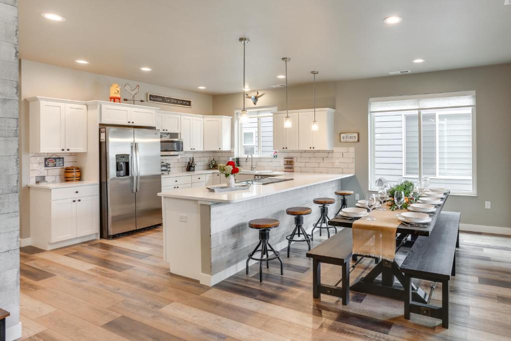 a kitchen with white cabinets and a table with chairs at Home Base for Final Rally Weekend w/ Heated Garage in Spearfish