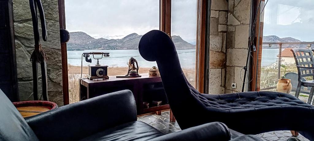 a room with two chairs in front of a window at Holiday home Haustor with Skadar lake view in Cetinje